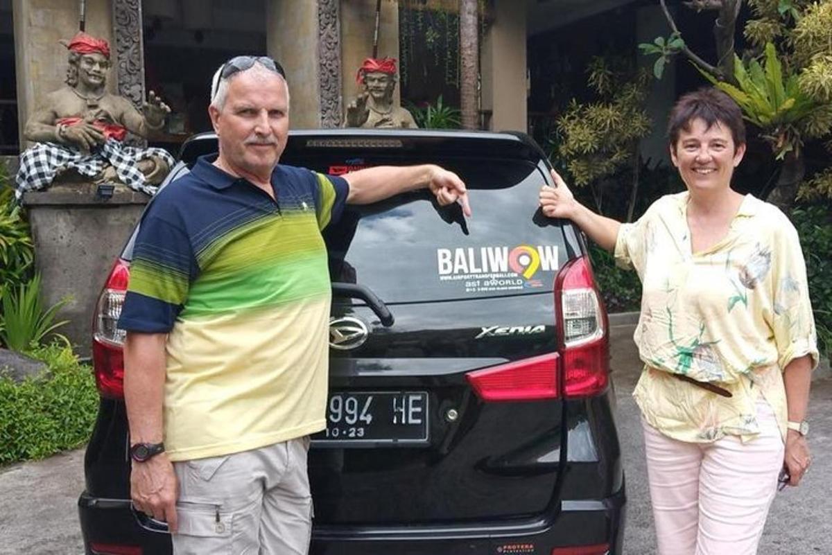 seorang lelaki dan seorang wanita berdiri di hadapan sebuah kereta