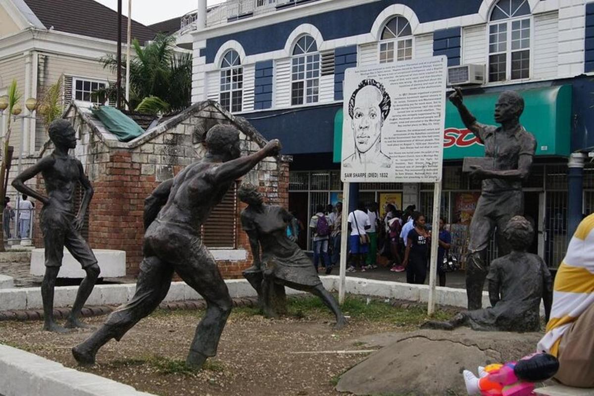 Una estatua de niños jugando béisbol en una calle.