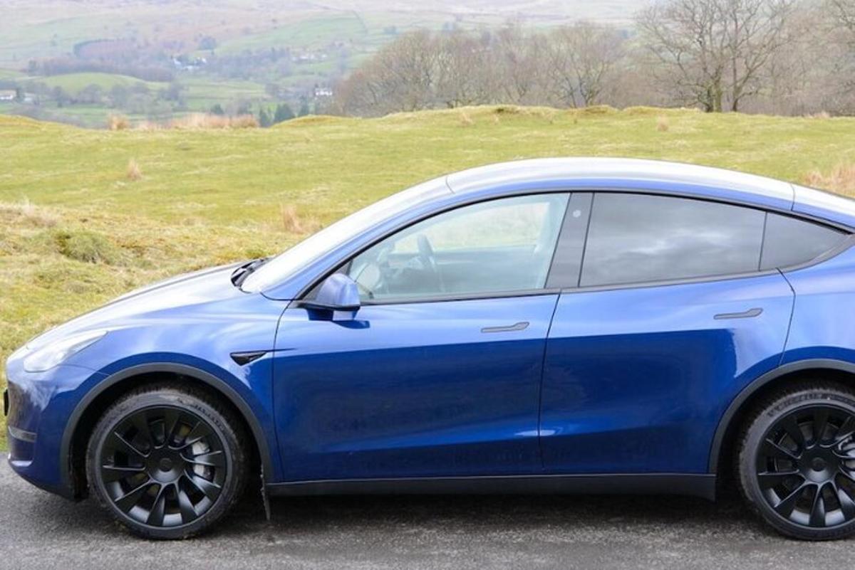 um carro azul estacionado no topo de uma colina