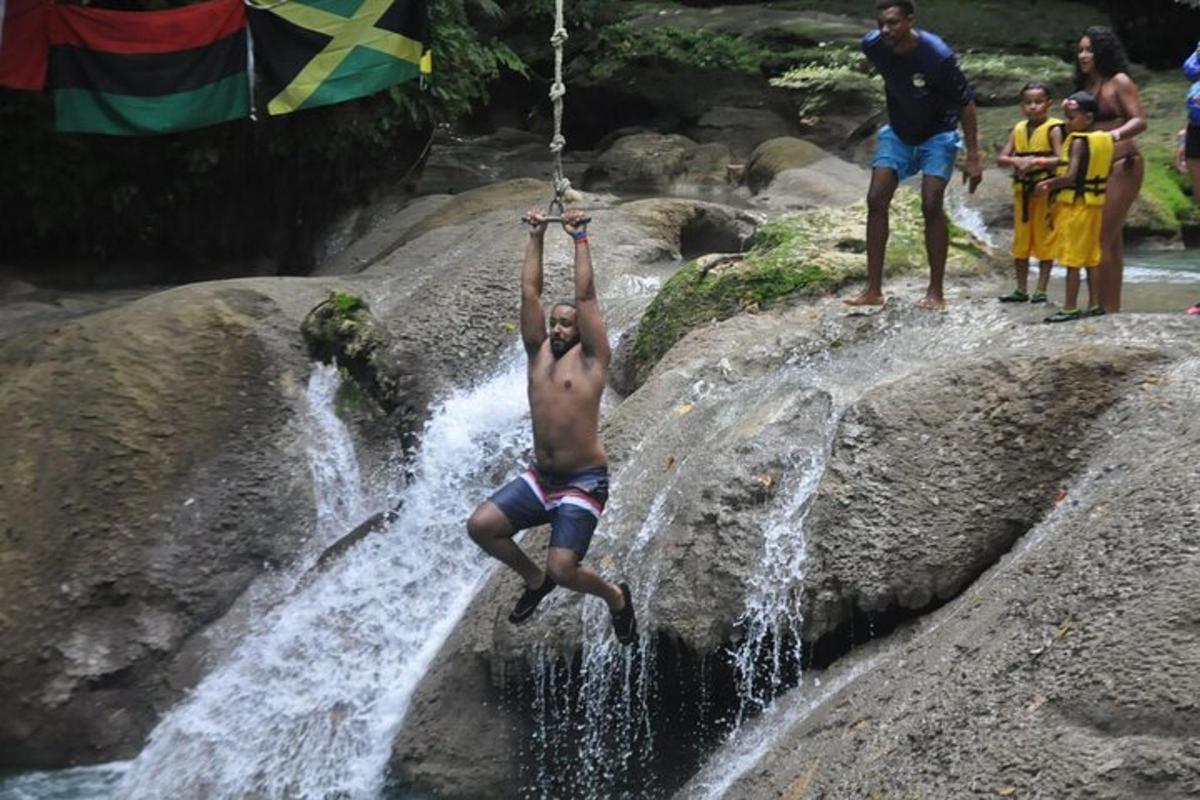Ein Mann hängt an einem Seil in einem Wasserfall