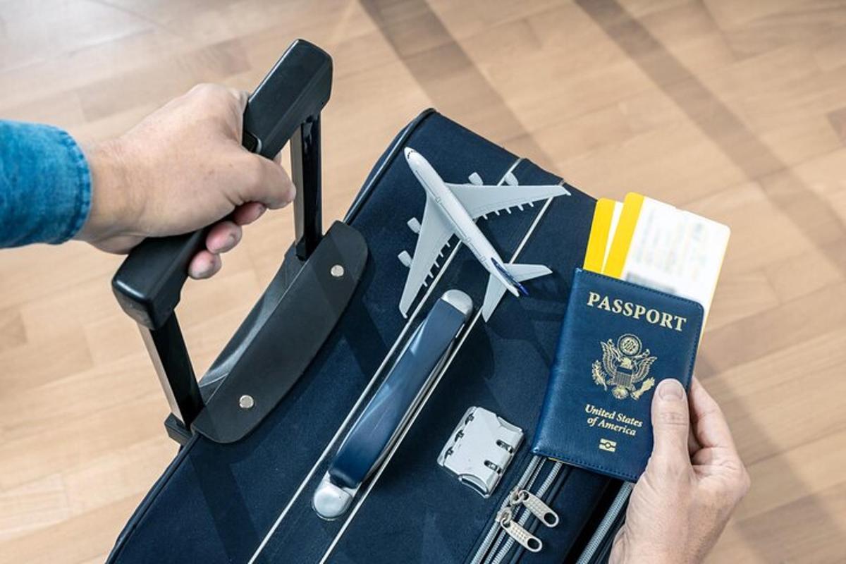 en person som holder et pass og et bord med en koffert