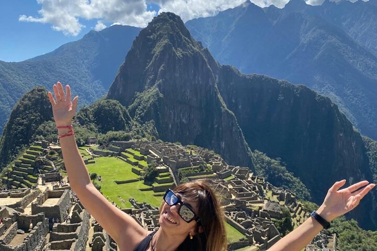 una donna con le braccia alzate tra le rovine