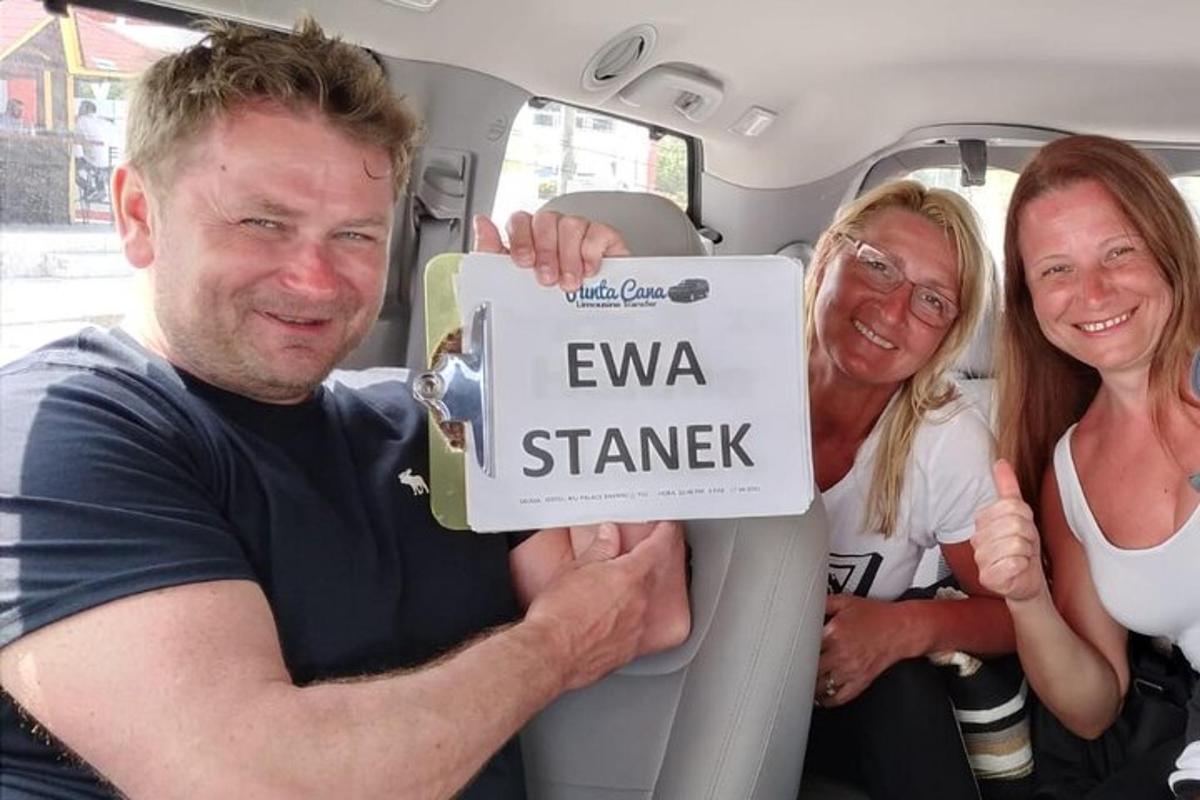 a man and two women holding a sign in the back of a van
