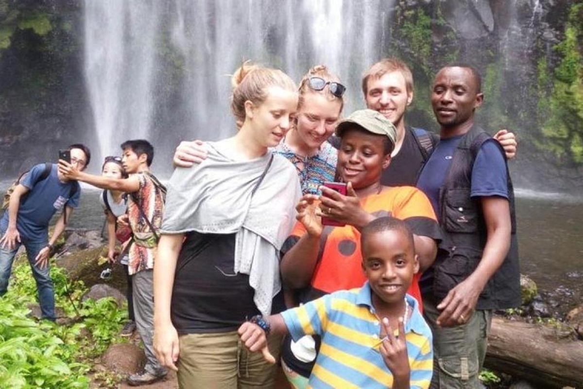 eine Gruppe von Menschen steht vor einem Wasserfall