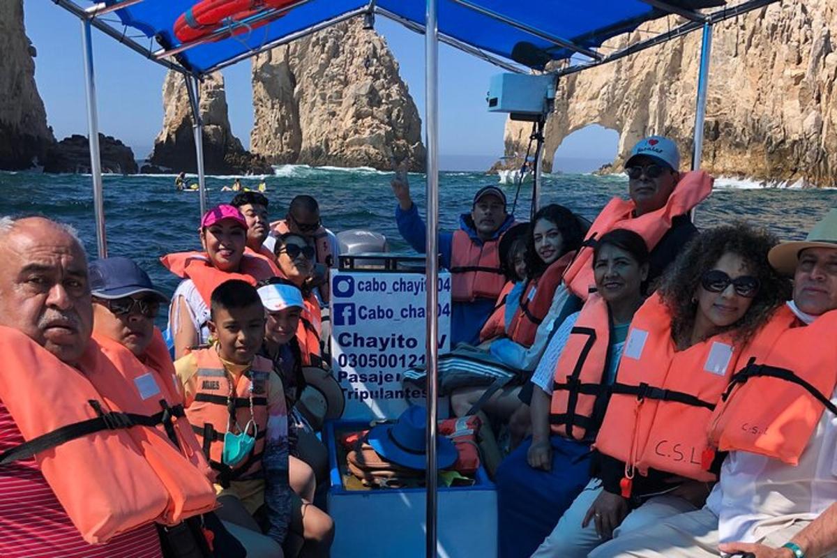 un grup de oameni în veste de salvare portocalii pe o barcă