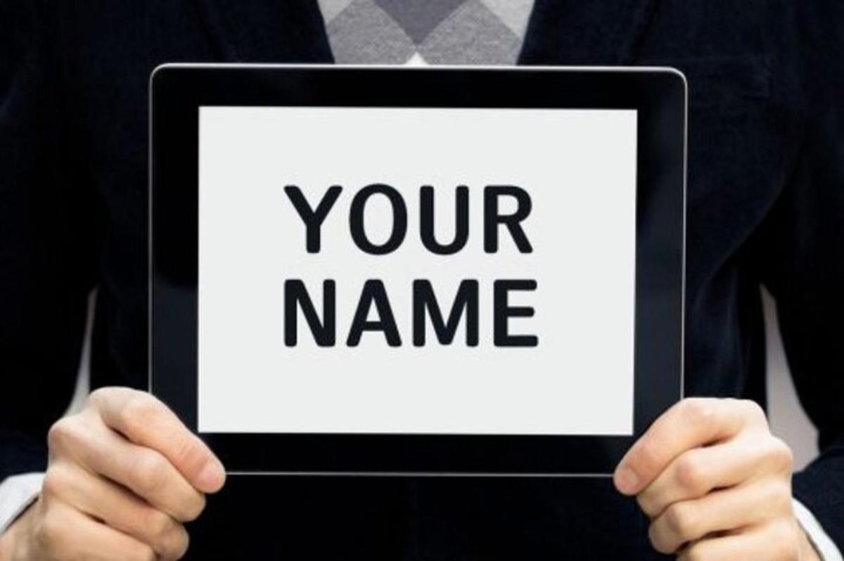 a man holding a sign that reads your name