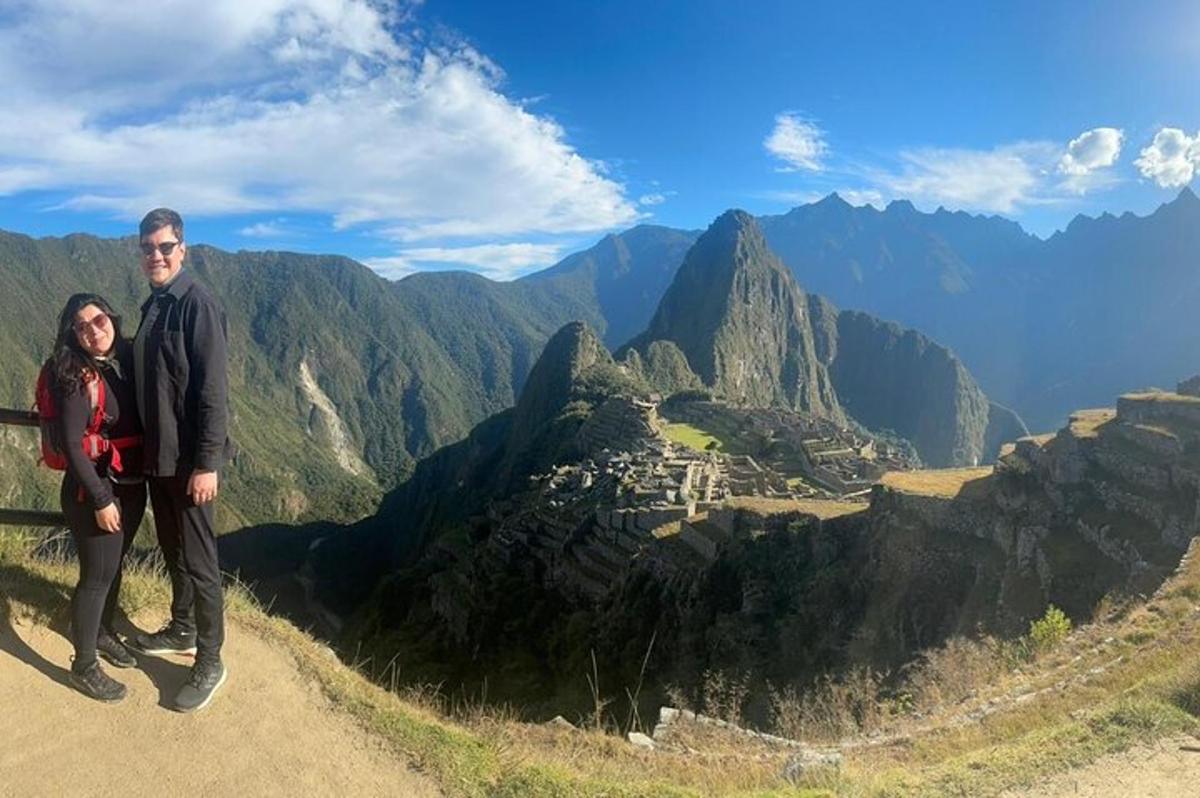a man and woman standing on top of a mountain