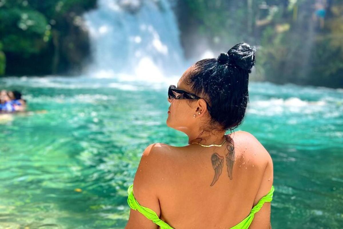 una donna in bikini in piedi davanti a una cascata