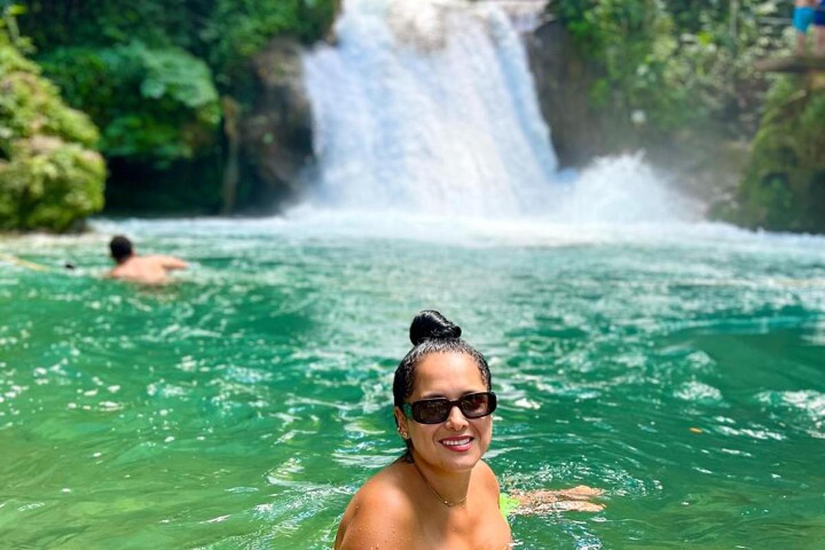 una donna in acqua davanti a una cascata