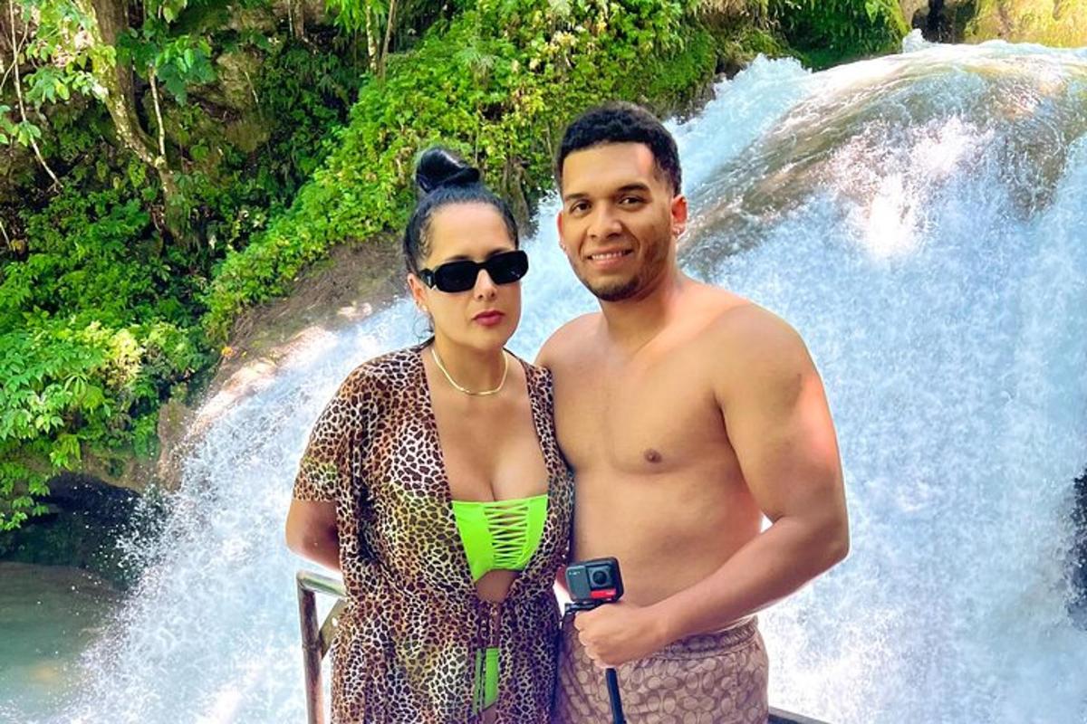 un uomo e una donna in piedi davanti a una cascata