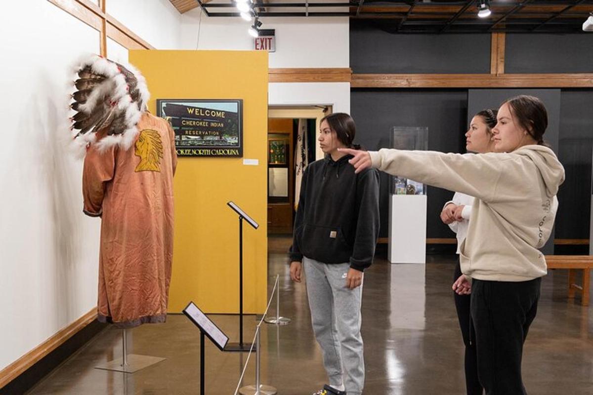 a woman pointing at a dress on a display in a museum