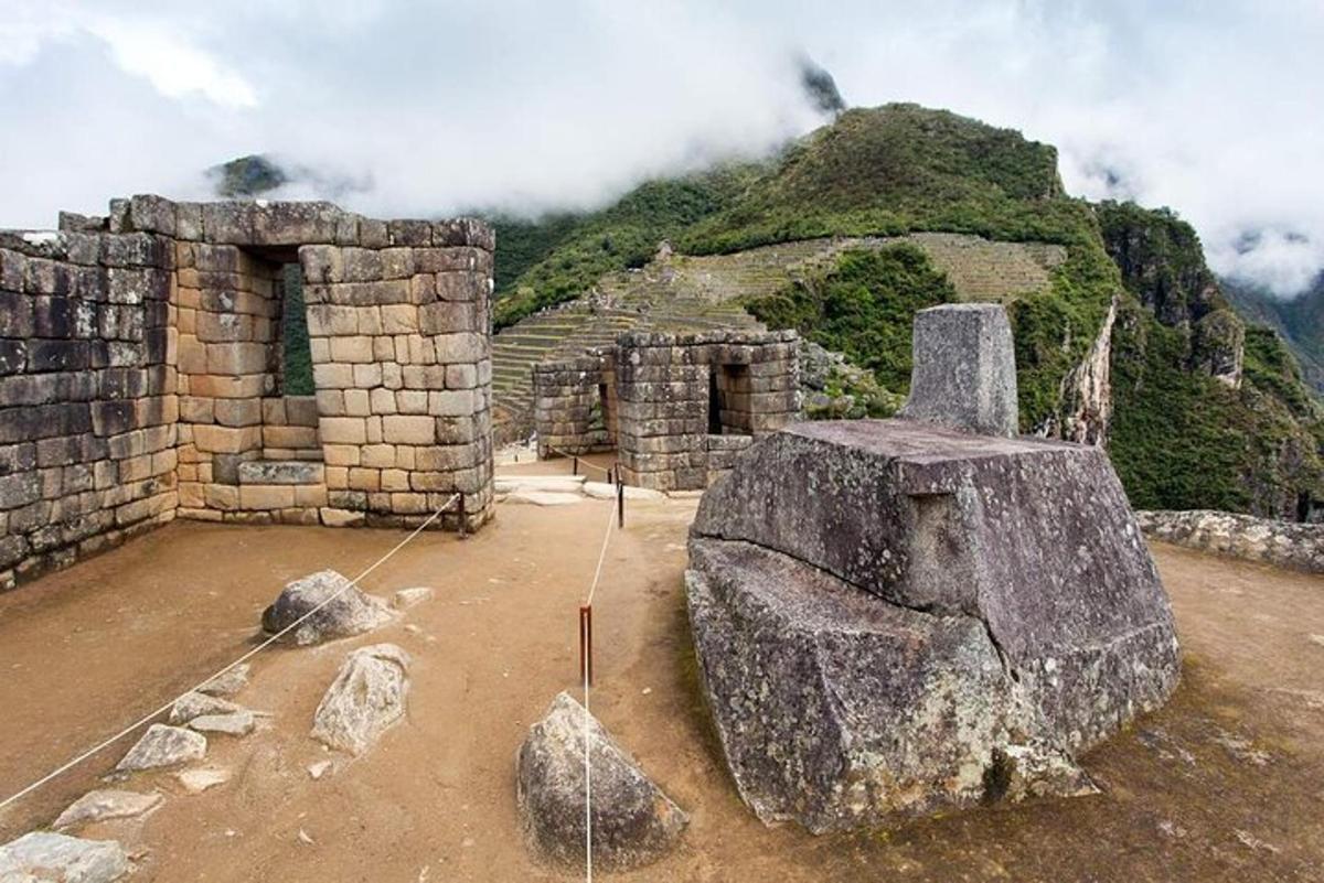 un bâtiment avec un gros rocher au sommet d'une montagne