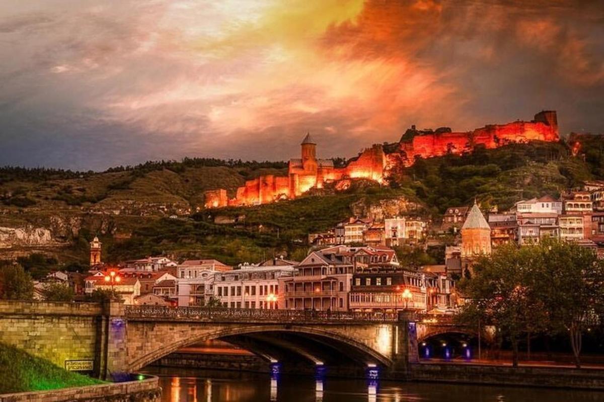 eine Stadt mit einer Brücke und einer Burg auf einem Hügel