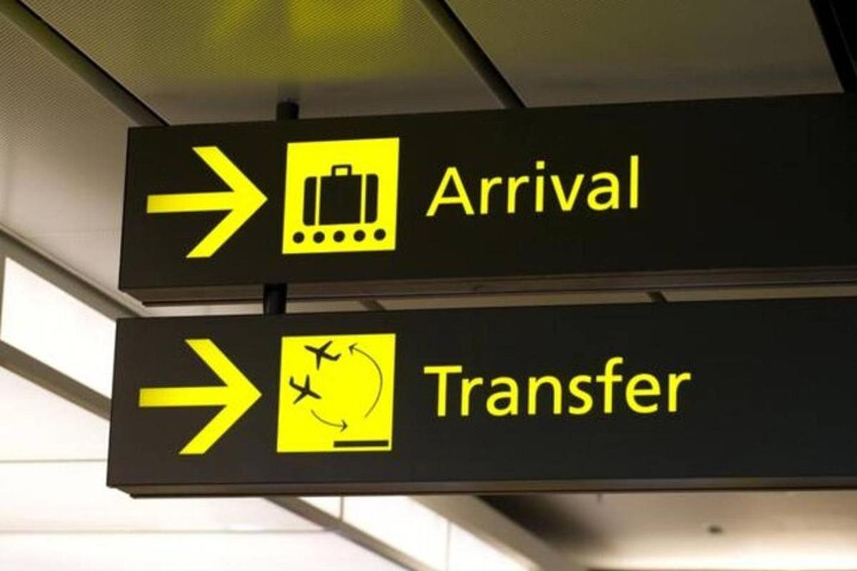 znak na lotnisku ze strzałkami i znakiem tranzytowym