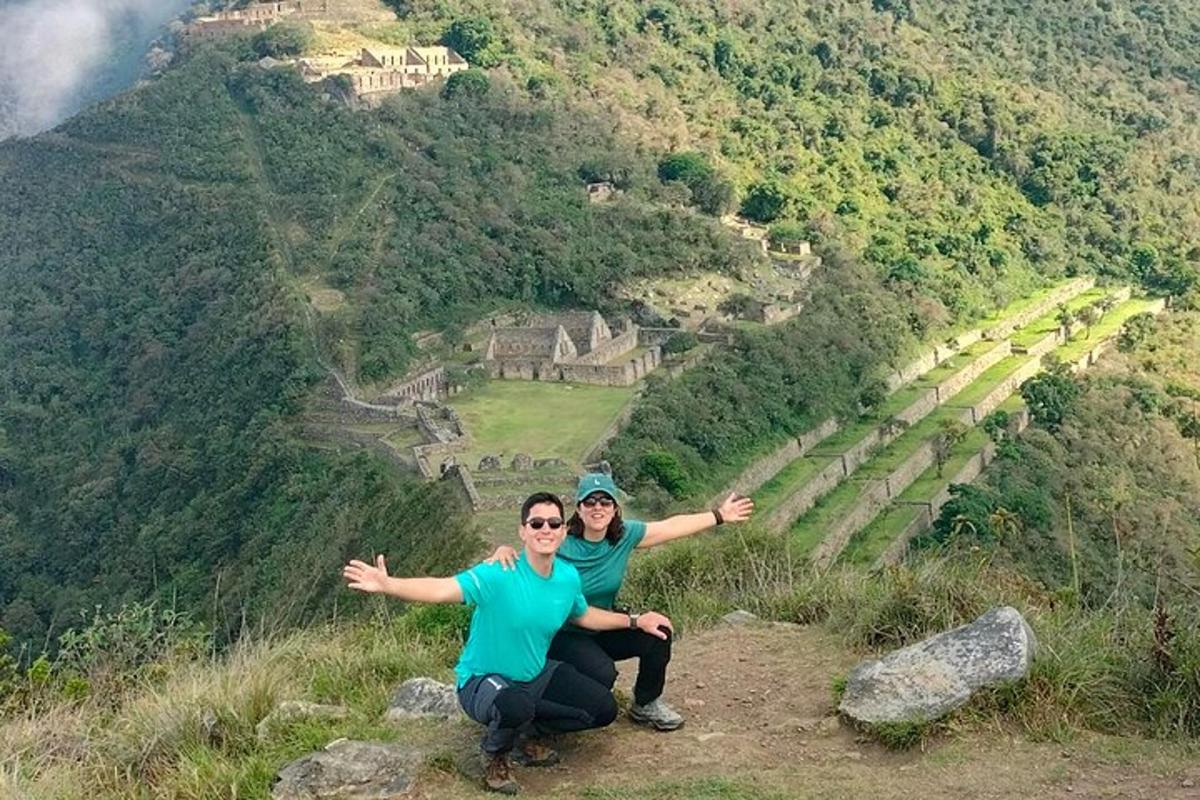 two people sitting on top of a mountain