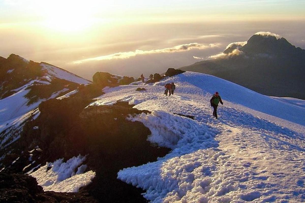 dua orang berjalan mendaki gunung yang dilitupi salji