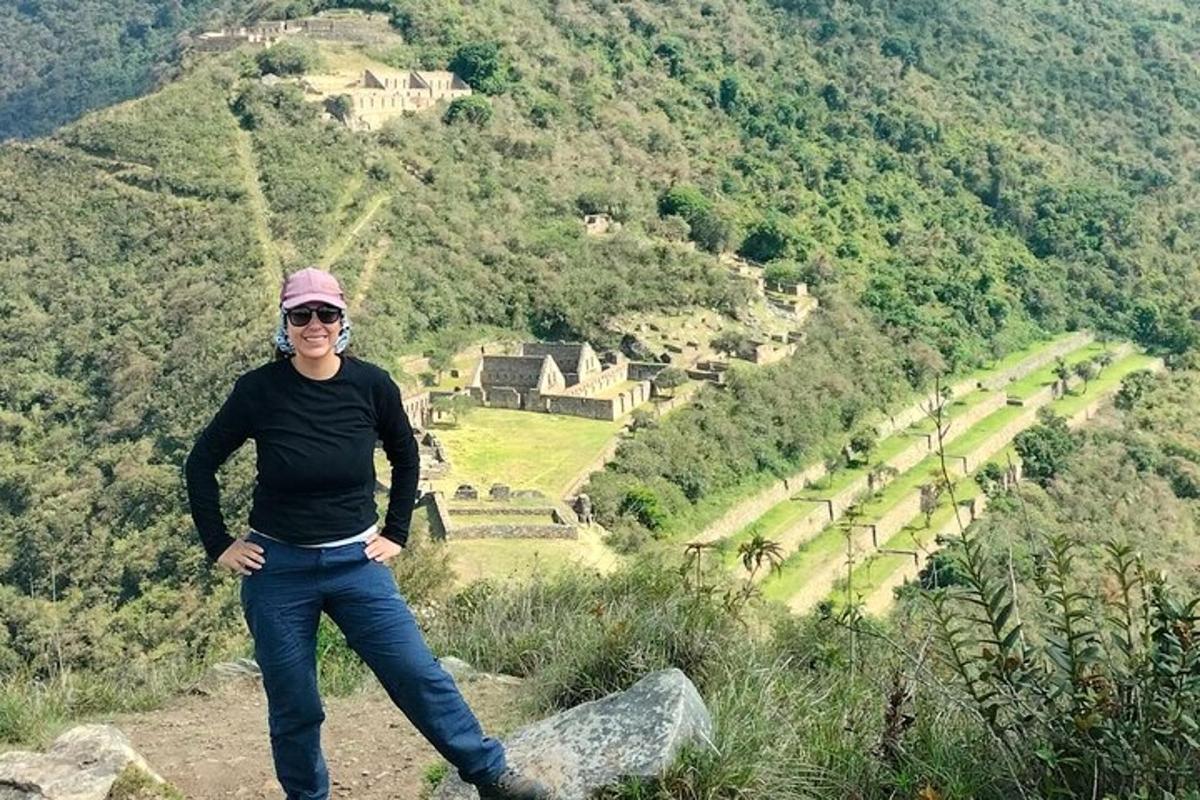 a woman standing on top of a rock on a mountain