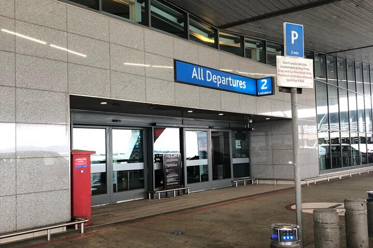 ein Flughafeneingang mit einem blauen Schild vor einem Gebäude