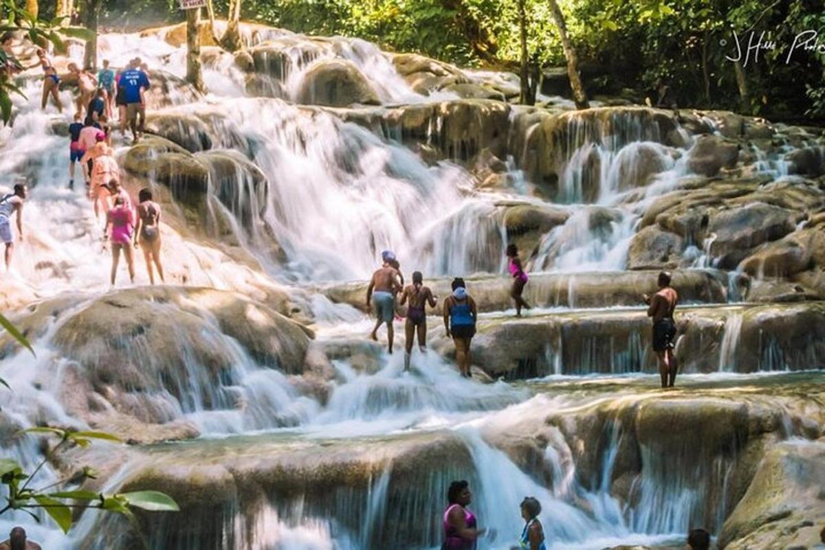 eine Gruppe von Menschen steht vor einem Wasserfall