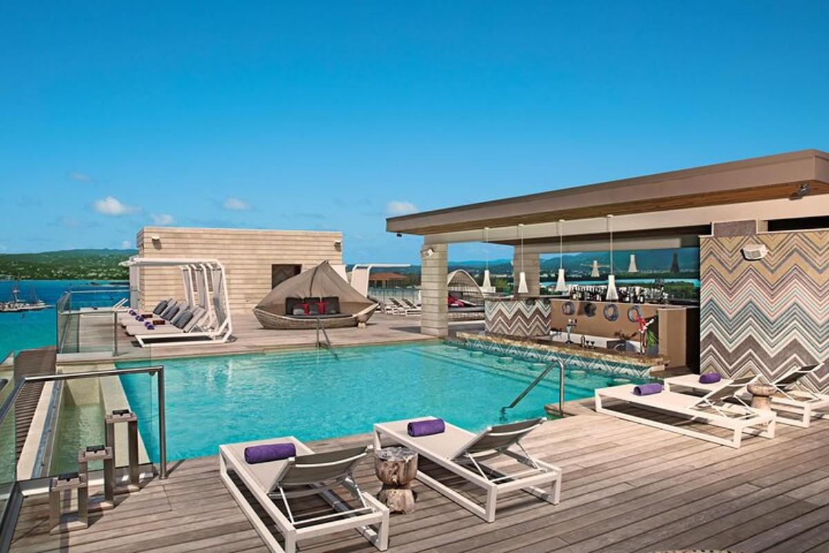 en swimmingpool med chaiselongstole på en terrasse