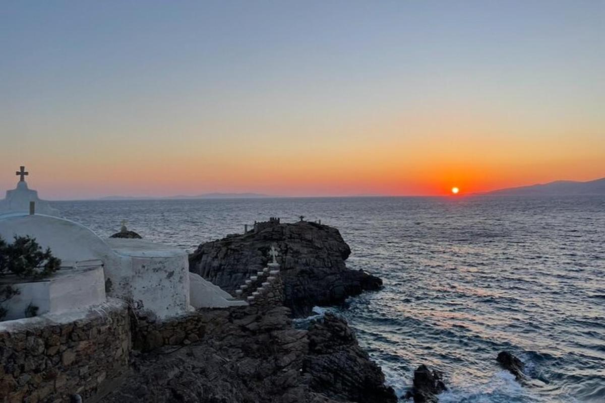 naplemente a víz felett egy templommal és az óceánnal