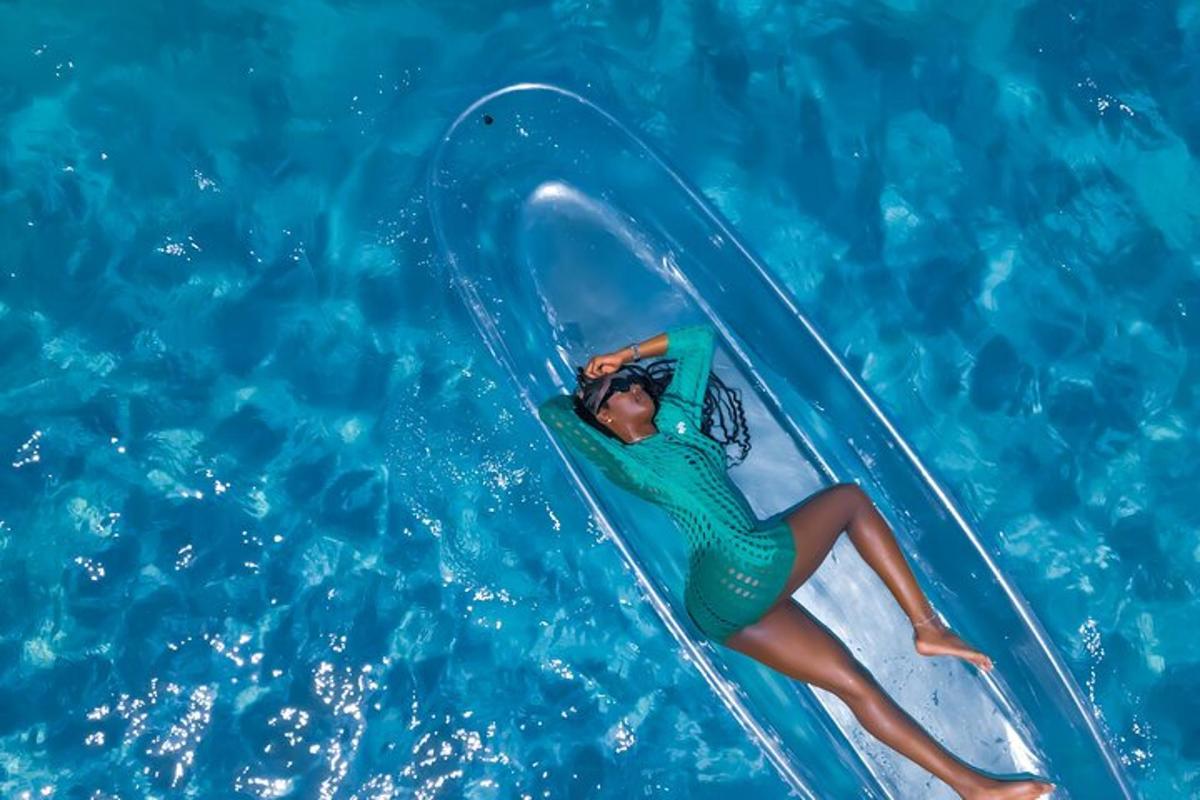 una dona cavalcant una onada sobre una taula de surf en una piscina