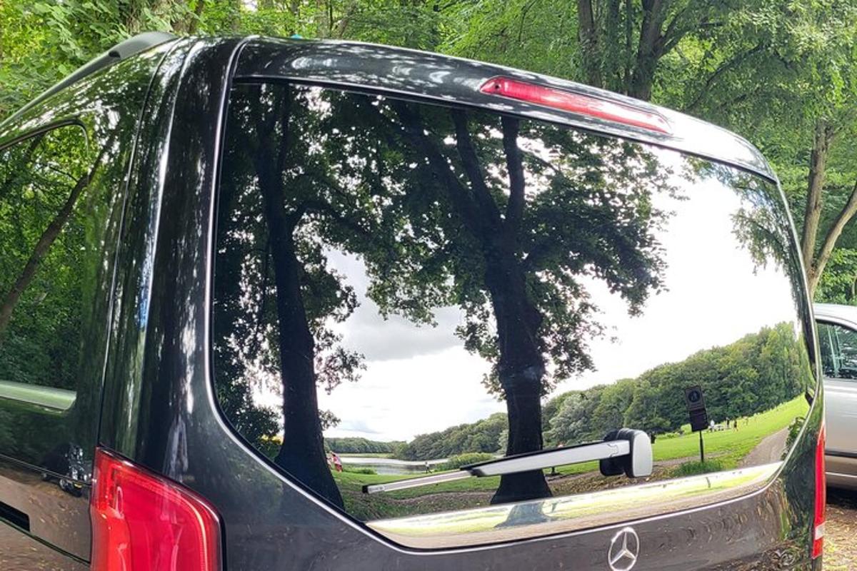 un'auto con il lunotto posteriore aperto con un riflesso di alberi