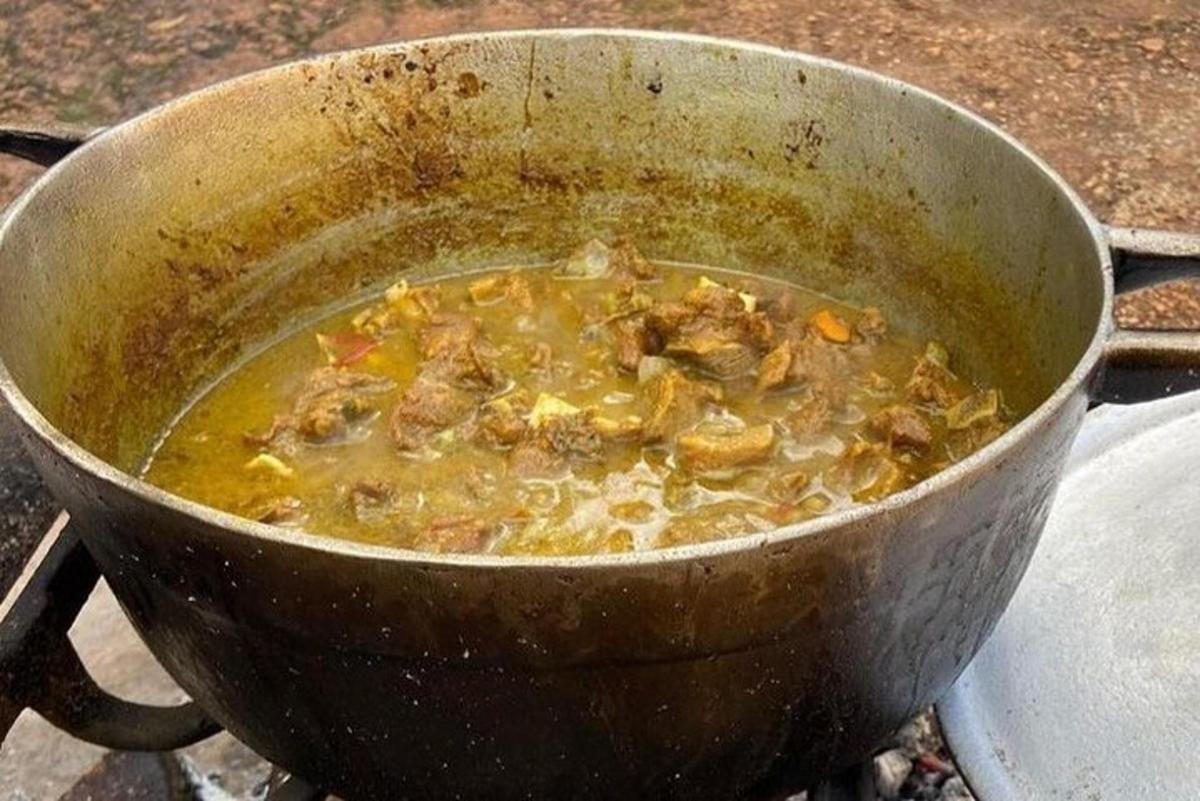 una pentola di cibo sta cuocendo su un fornello