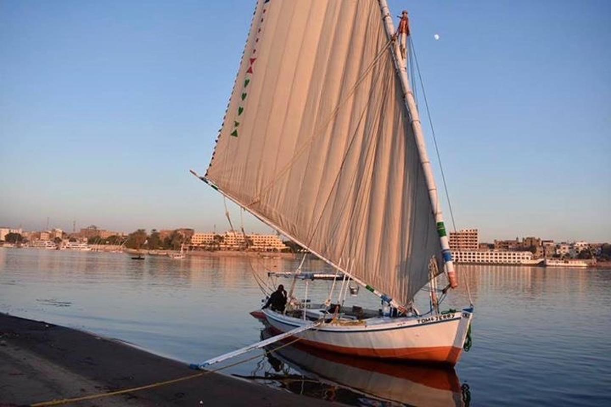 een kleine zeilboot die op het water ligt
