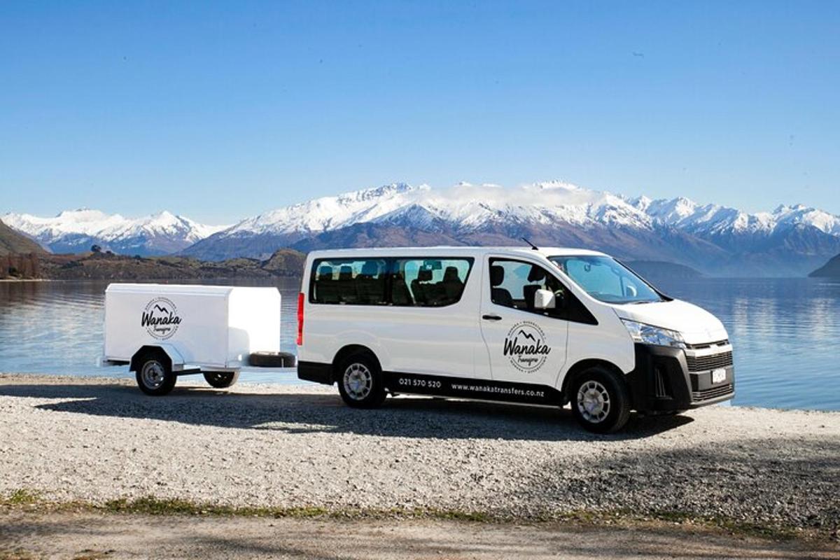 bel kombi in prikolica parkirana ob vodni površini