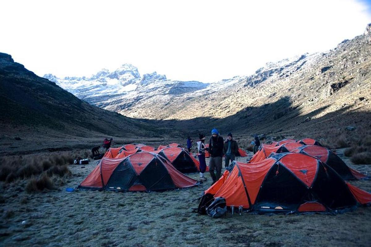 sekumpulan khemah di padang dengan gunung