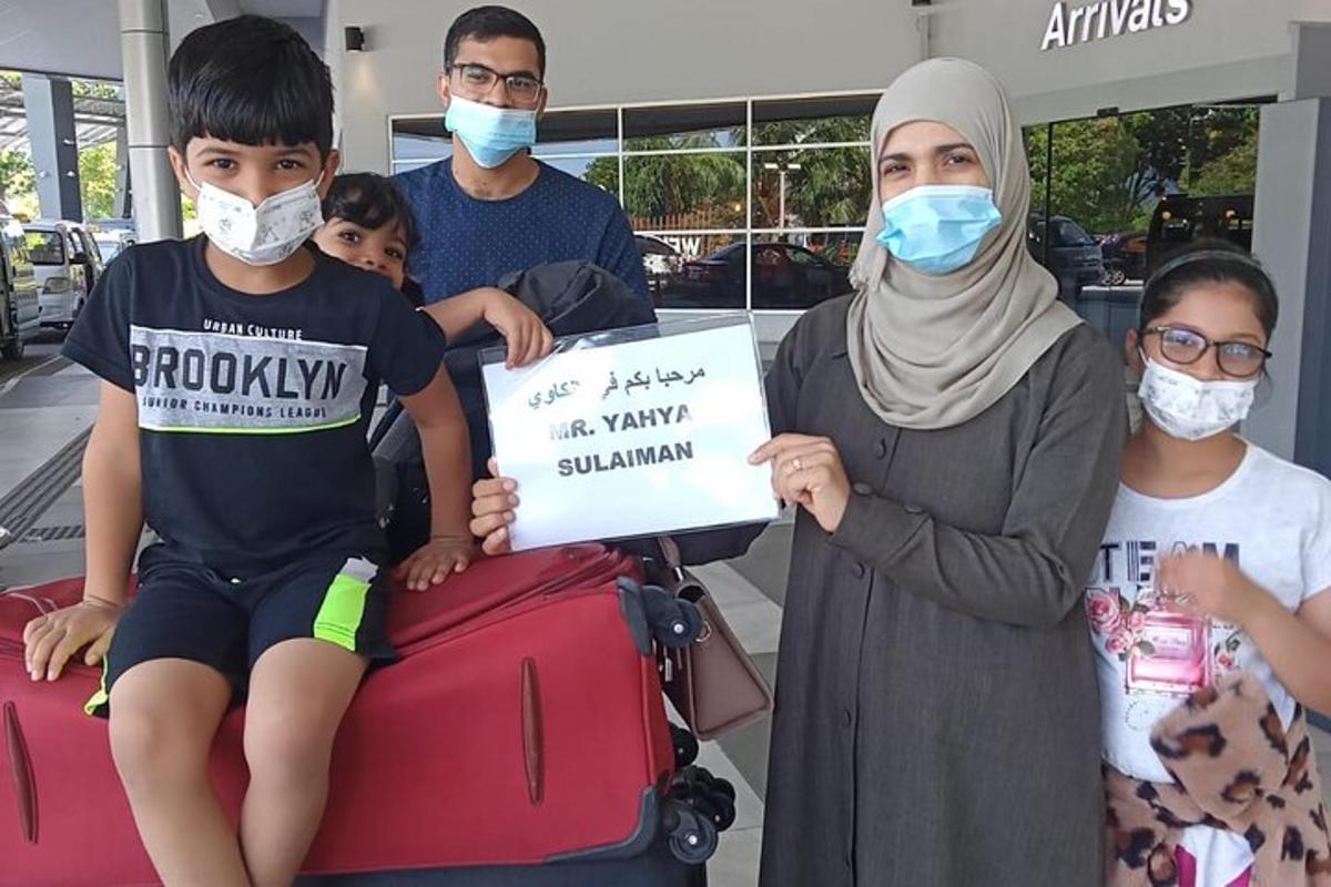 um grupo de pessoas segurando uma placa em um aeroporto