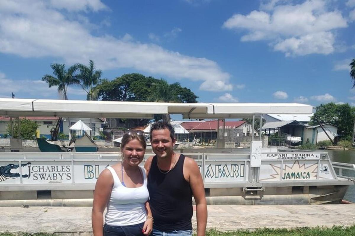 Un hombre y una mujer de pie frente a un barco
