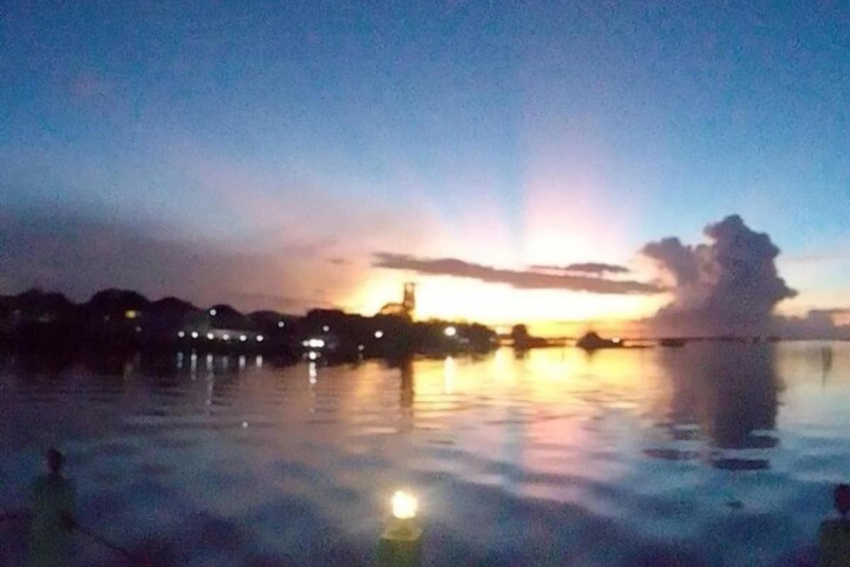 una posta de sol sobre una massa d'aigua amb la posta de sol