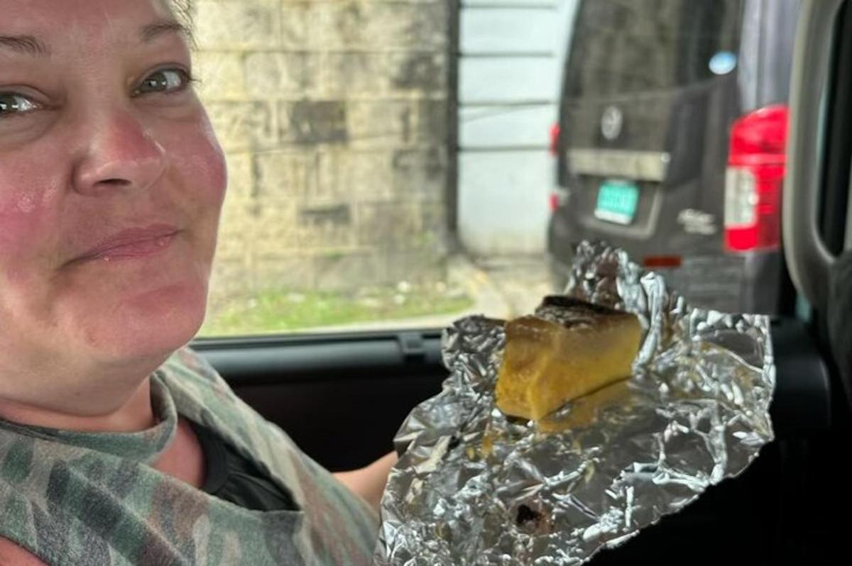 a man sitting in a car holding a piece of food