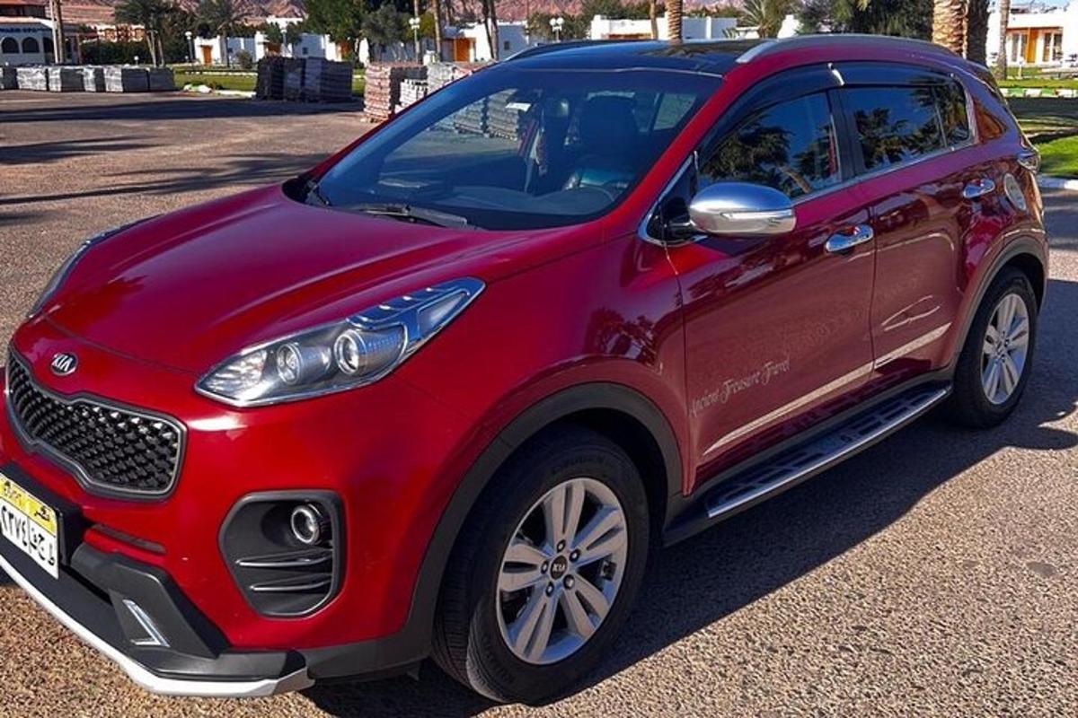 en rød smart-bil parkeret på en parkeringsplads