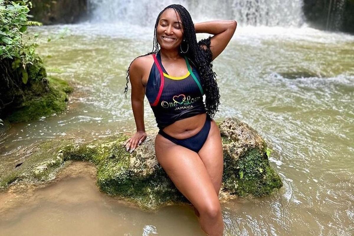 une femme est assise sur un rocher dans l'eau