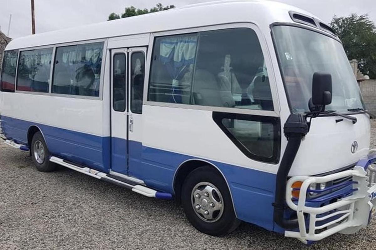 a blue and white bus parked in a parking lot