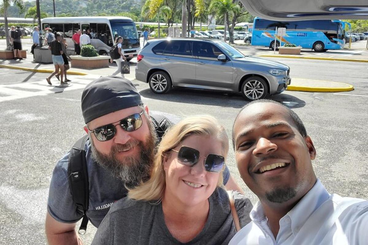 tre persone posano per una foto in un parcheggio