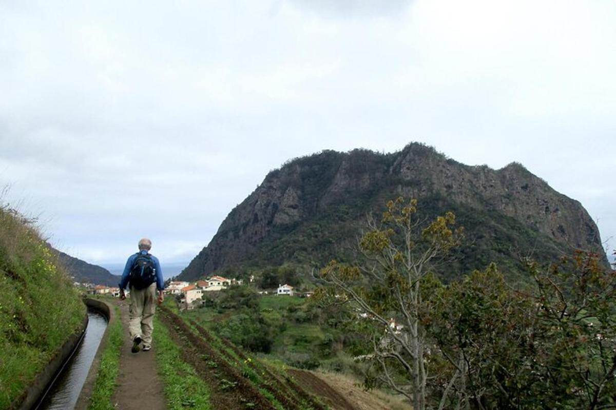 um homem caminhando por um caminho perto de uma montanha