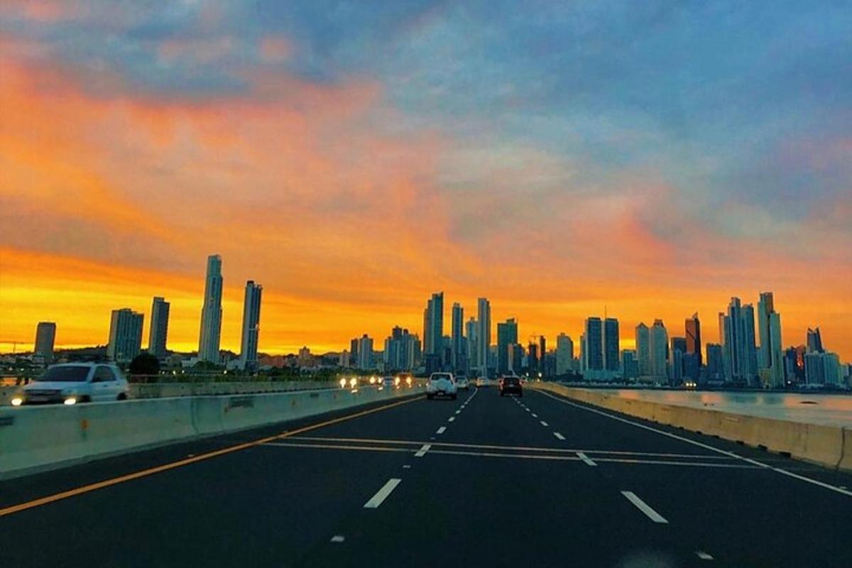 un'autostrada con vista di una città al tramonto