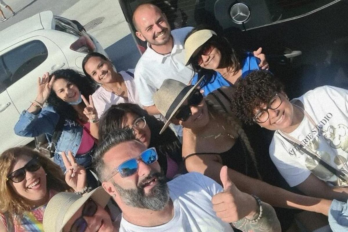 een groep mensen die poseren voor een foto voor een auto