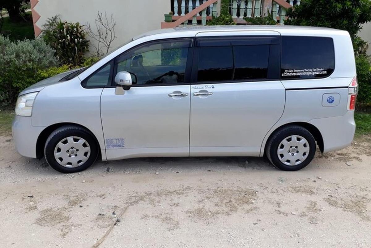 một chiếc xe tải nhỏ màu trắng đậu trong đường lái xe