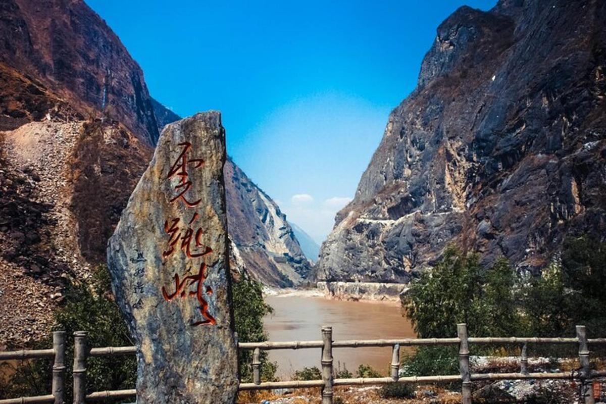 a rock with writing on it next to a river
