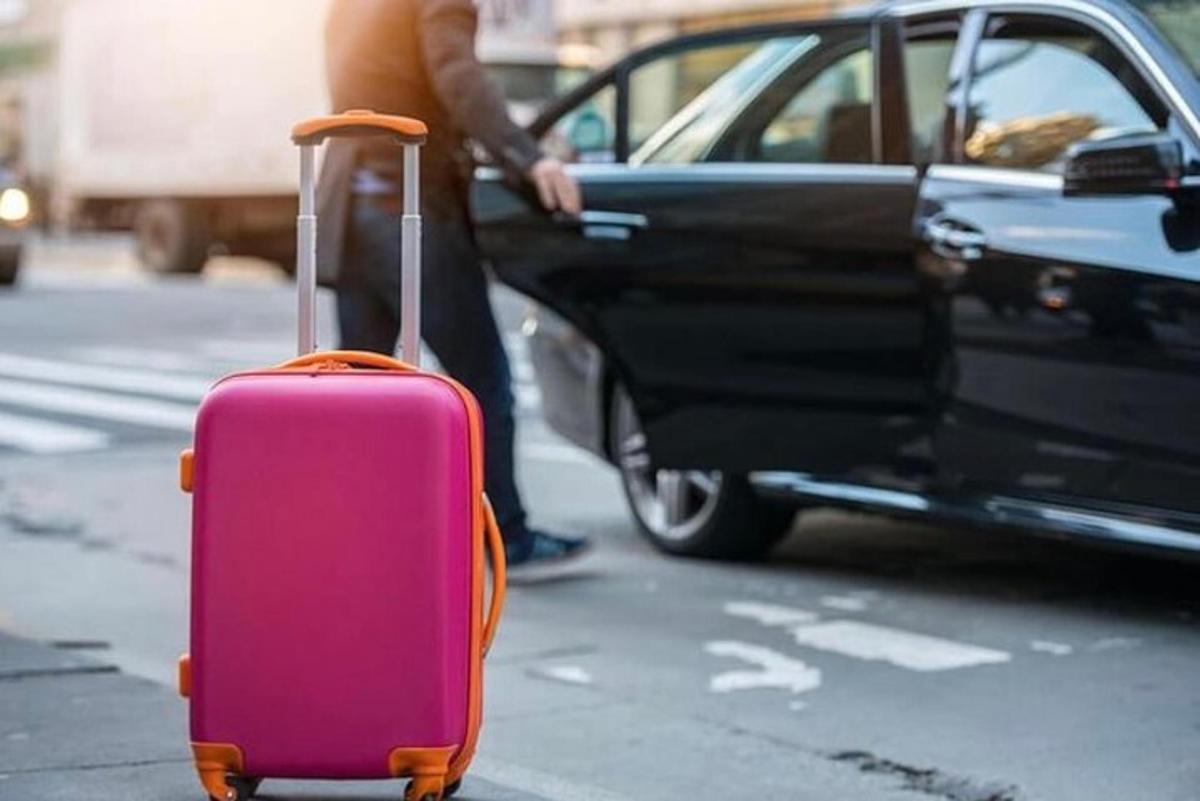seseorang dengan beg pakaian merah jambu di sebelah kereta