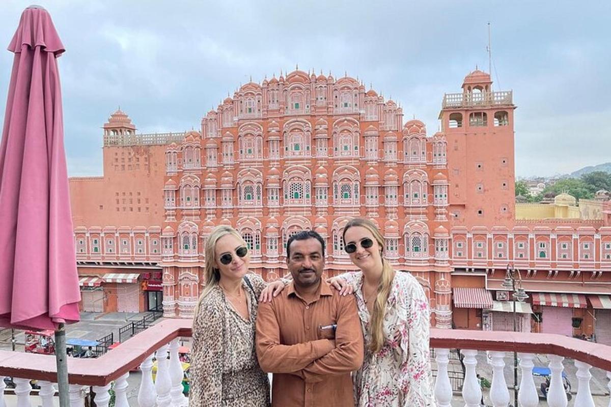 a man and two women standing in front of a large building
