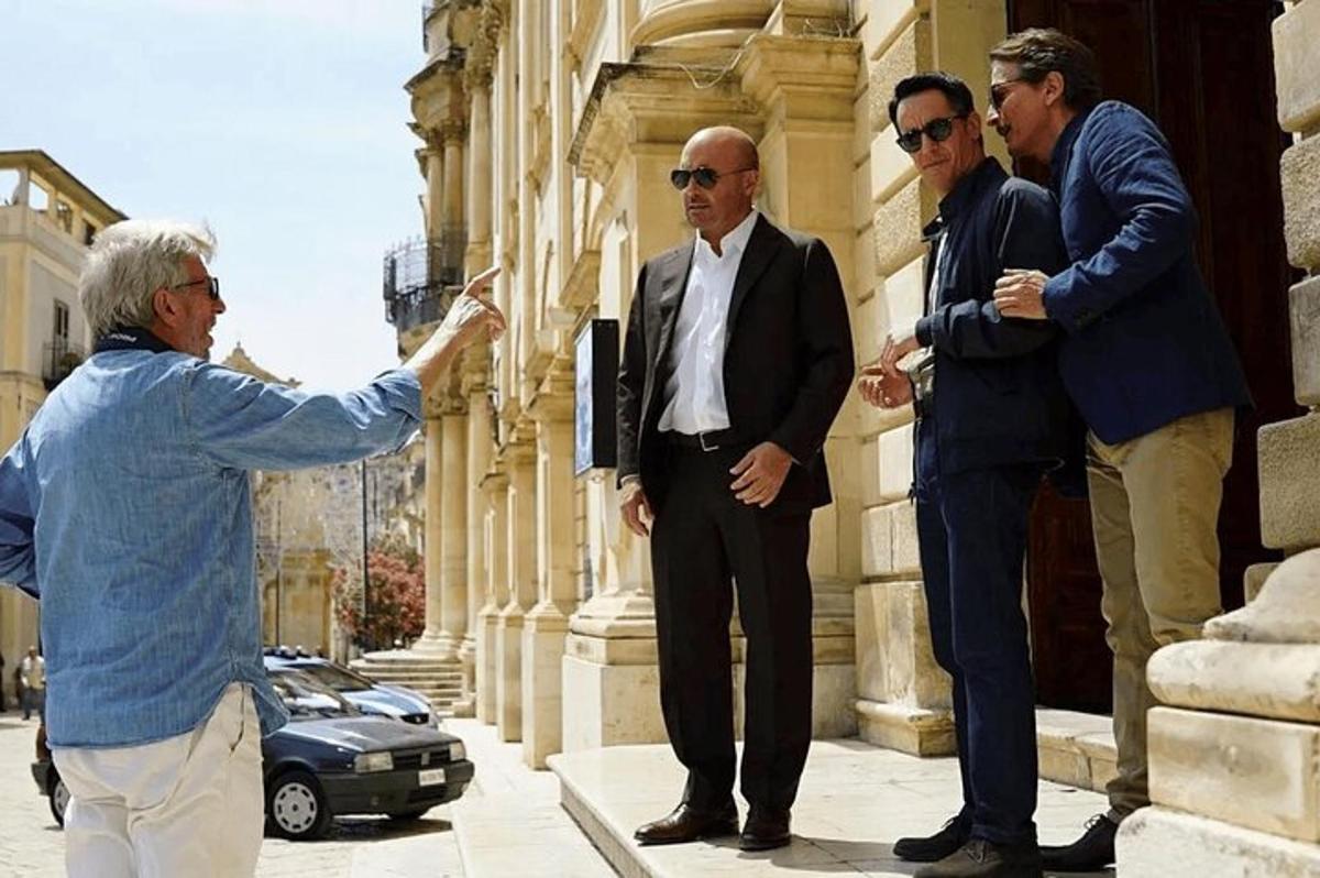 hópur karla sem standa fyrir utan byggingu