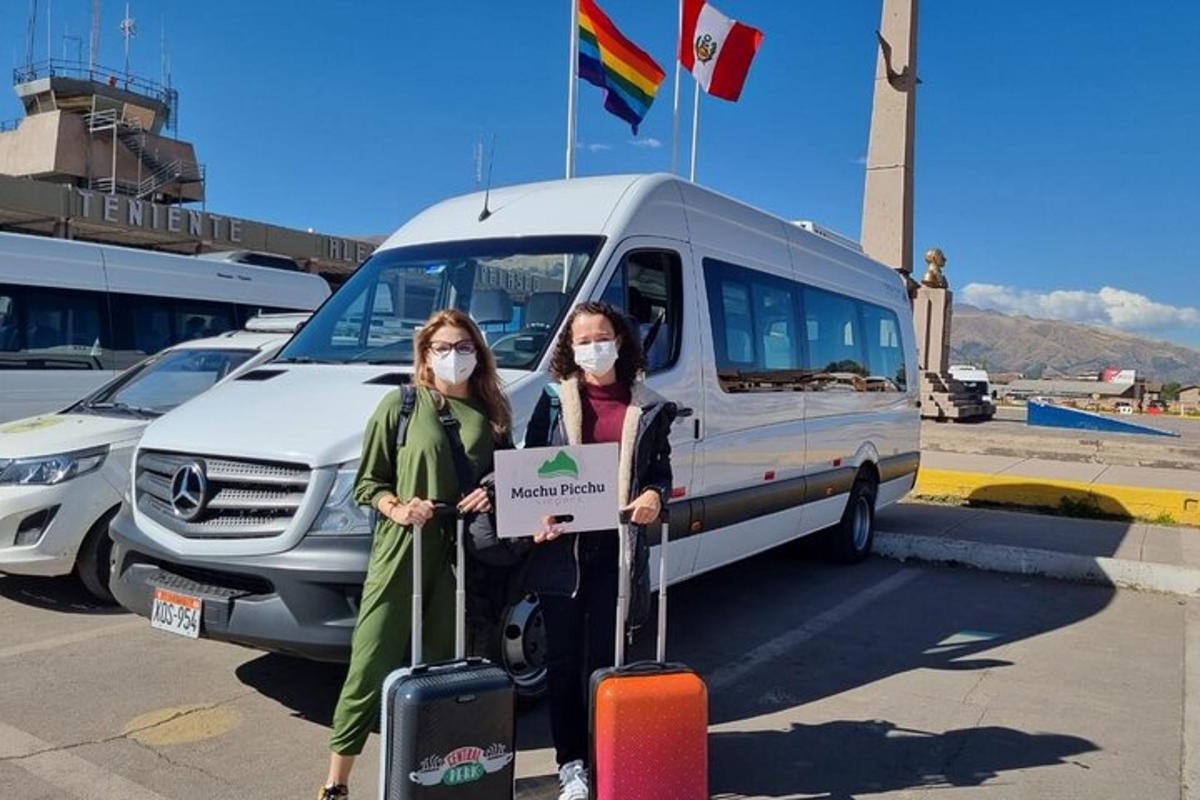Dos mujeres con máscaras paradas frente a una camioneta
