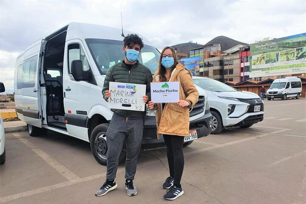 Un hombre y una mujer sosteniendo un cartel en un estacionamiento.