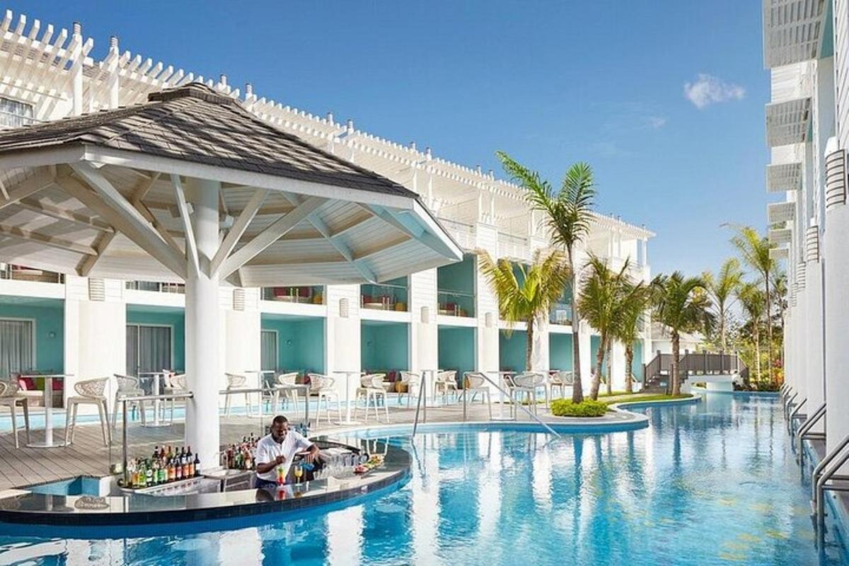 un uomo seduto a un tavolo in una piscina di un resort